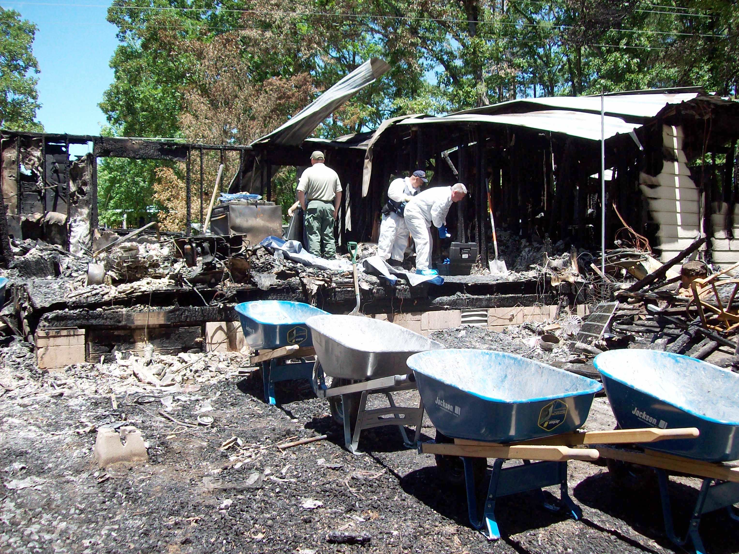 Rubble removal underway, part of the house blackened, but still standing. 